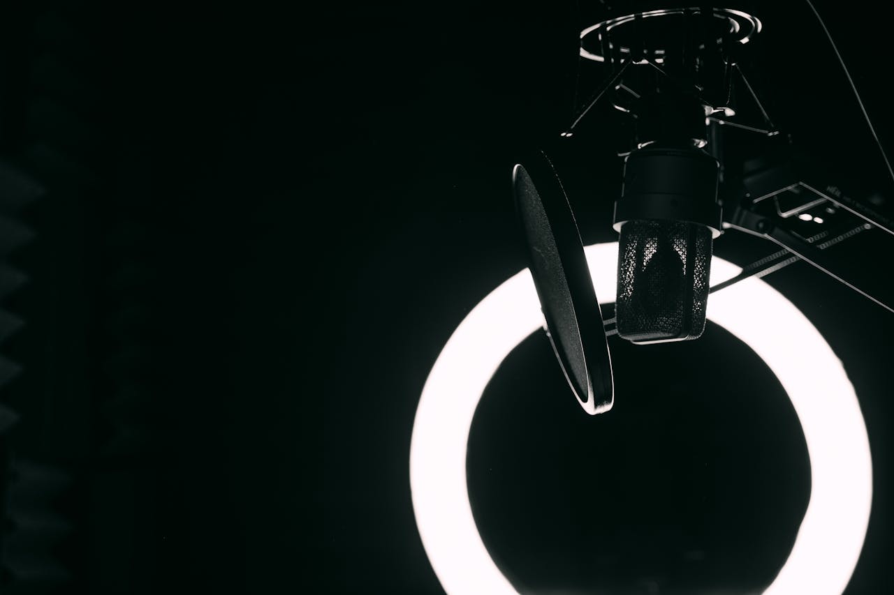 A close-up view of a microphone and ring light in a professional recording studio setting.
